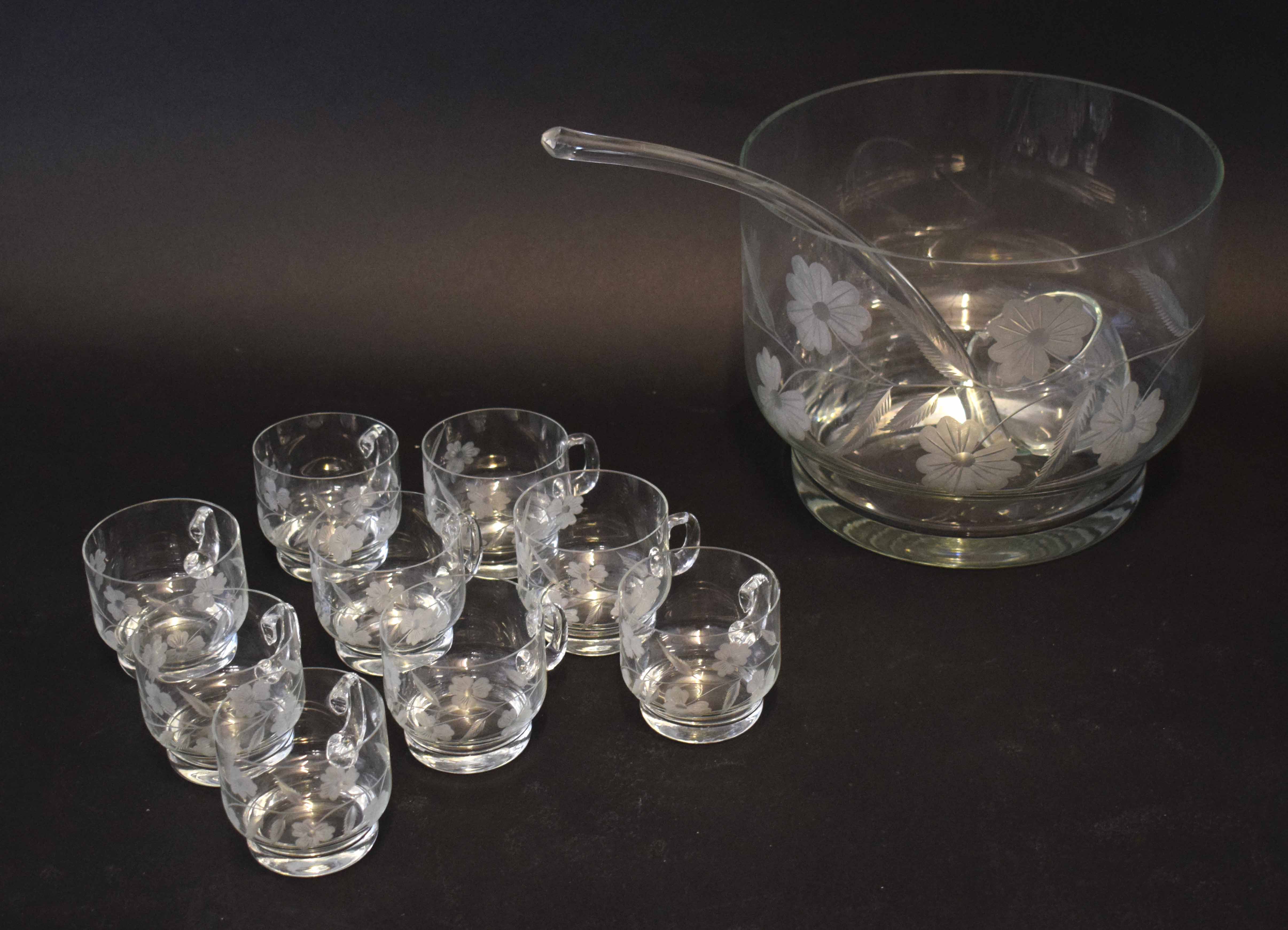 Large glass punch bowl with glass serving scoop and nine small punch glasses, all with loop
