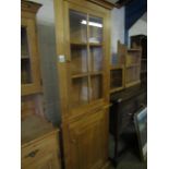 MODERN OAK FRAMED FLOOR STANDING CORNER CUPBOARD WITH SINGLE GLAZED DOOR OVER PANELLED DOOR WITH