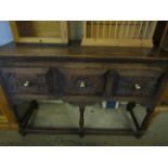 OAK FRAMED SIDEBOARD WITH THREE DRAWERS WITH CARVED DETAIL ON TURNED LEGS WITH BRASS KNOB HANDLES