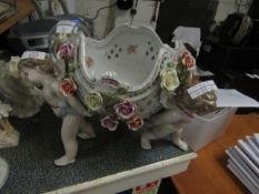 GERMAN PORCELAIN CENTREPIECE WITH FLOWER ENCRUSTED DECORATION AND PIERCED SIDES WITH THREE PUTTI