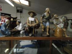 GROUP OF ORIENTAL POTTERY FIGURES MODELLED AS FISHERMEN IN VARIOUS POSES, THE TALLEST 22CM HIGH (4)