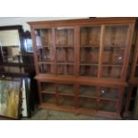 BEECH WOOD SHOP DISPLAY CABINET FITTED WITH EIGHT GLAZED SECTIONAL DOORS RAISED ON BUN FEET