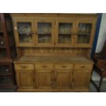 GOOD QUALITY WAXED PINE DRESSER, THE TOP FITTED WITH FOUR GLAZED DOORS, THE BASE WITH FOUR DRAWERS