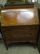 TEAK FRAMED DROP FRONTED BUREAU WITH THREE FULL WIDTH DRAWERS WITH RINGLET HANDLES RAISED ON PAD