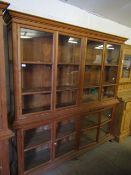 BEECH WOOD SHOP DISPLAY CABINET FITTED WITH EIGHT GLAZED SECTIONAL DOORS RAISED ON BUN FEET