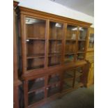 BEECH WOOD SHOP DISPLAY CABINET FITTED WITH EIGHT GLAZED SECTIONAL DOORS RAISED ON BUN FEET