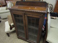 OAK FRAMED BOOKCASE WITH TWO LEADED AND GLAZED DOORS, RAISED ON BRACKET FEET