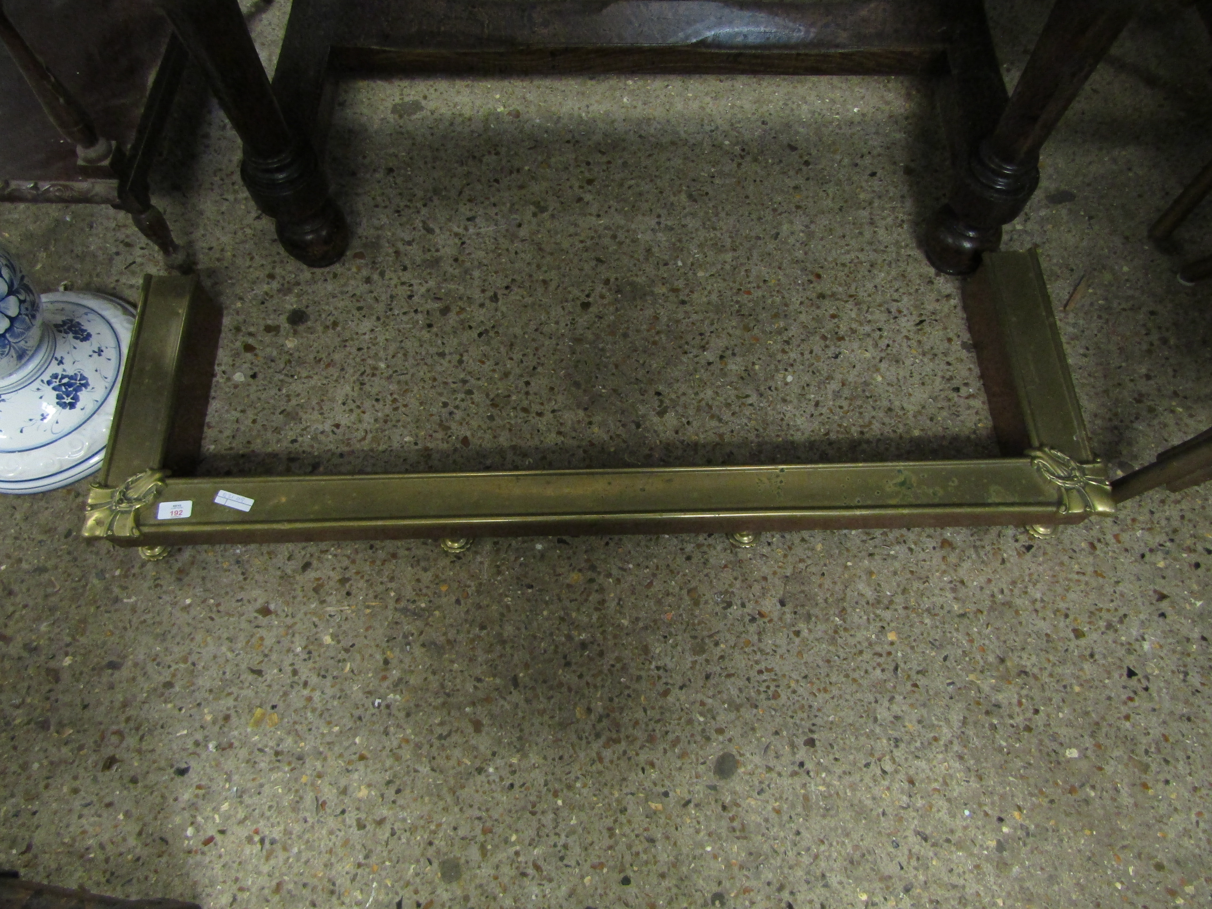 VICTORIAN PRESSED BRASS FENDER RAISED ON FOUR SHAPED FEET