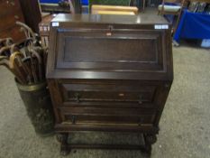 EARLY 20TH CENTURY OAK FRAMED BUREAU WITH DROP FRONT FITTED WITH FULL WIDTH DRAWERS ON CARVED STAND