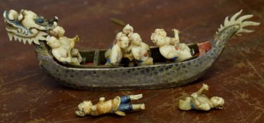 Group of small ivory figures of sailors in a longboat, the helm modelled with a dragon's head and