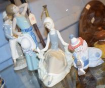 Group of Lladro porcelain figures including a clown, a young girl seated with a dove and two further