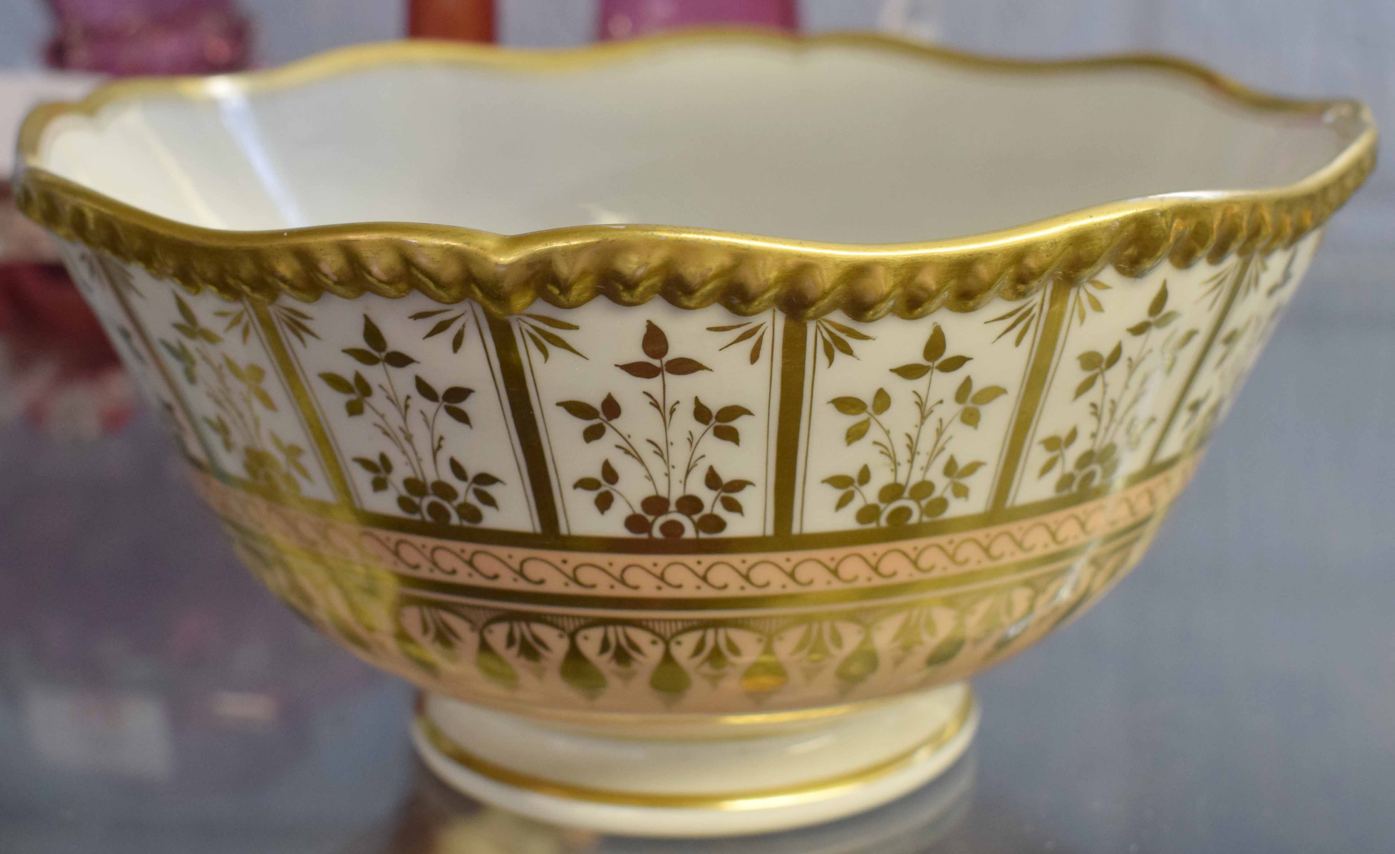 Worcester type bowl of lobed form, the salmon pink ground with gilded decoration with richly