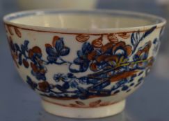 Lowestoft tea bowl, the blue and white design with iron red overglaze floral decoration, 8cm diam