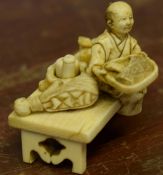 Early 20th century miniature model of a street vendor seated on a rectangular base offering his