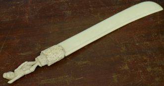 Large ivory model of a sword with carved hilt and man above, 36cm long