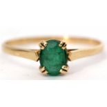 Yellow metal emerald ring, the oval faceted emerald 8x6mm, four claw set and raised between plain