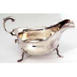 Edward VII gravy boat of typical polished form with cut card rim and leaf capped flying C-scroll