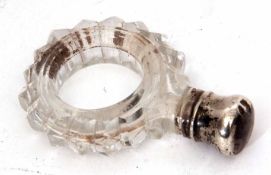 Late 19th century silver lidded and clear cut glass ring formed scent bottle, the faceted cut body