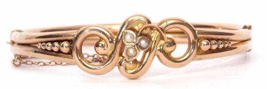 9ct stamped and seed pearl hinged bracelet, the tubular bead and scroll frame with a cluster seed