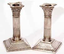 Pair of George V candlesticks modelled as Corinthian columns with detachable nozzles on stepped