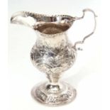 George III milk jug of baluster form with shaped rim, cast and applied leaf capped handle and body