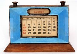 George V guilloche enamelled desk calendar, the rectangular frame on a flared base with an applied