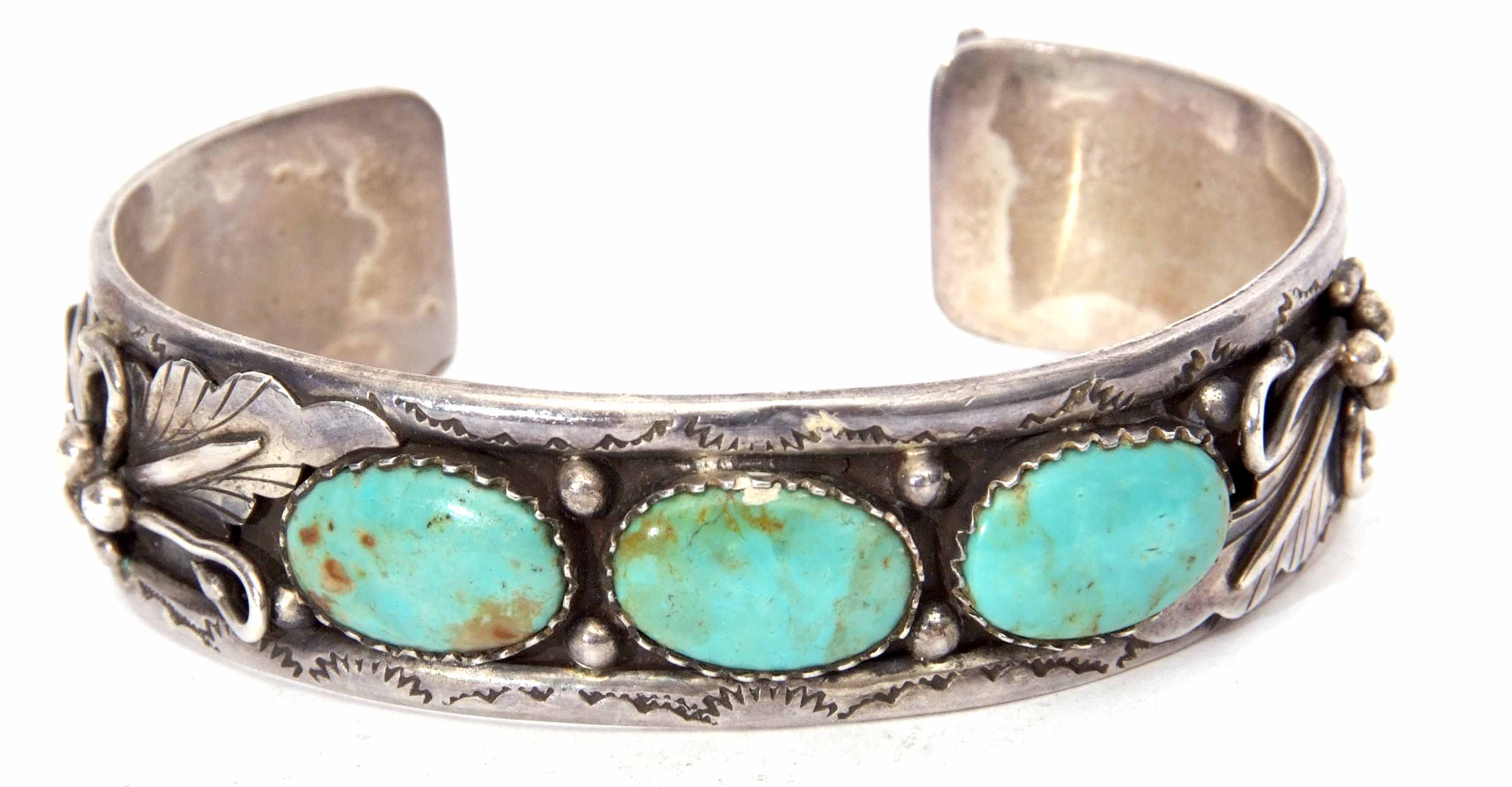 White metal and turquoise set torque bangle, an ornate leaf and bead design featuring three collet