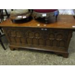 OAK FRAMED SMALL COFFER WITH DECORATIVE TOP ARCHED PANELLED FRONT RAISED ON SHAPED BRACKET FEET