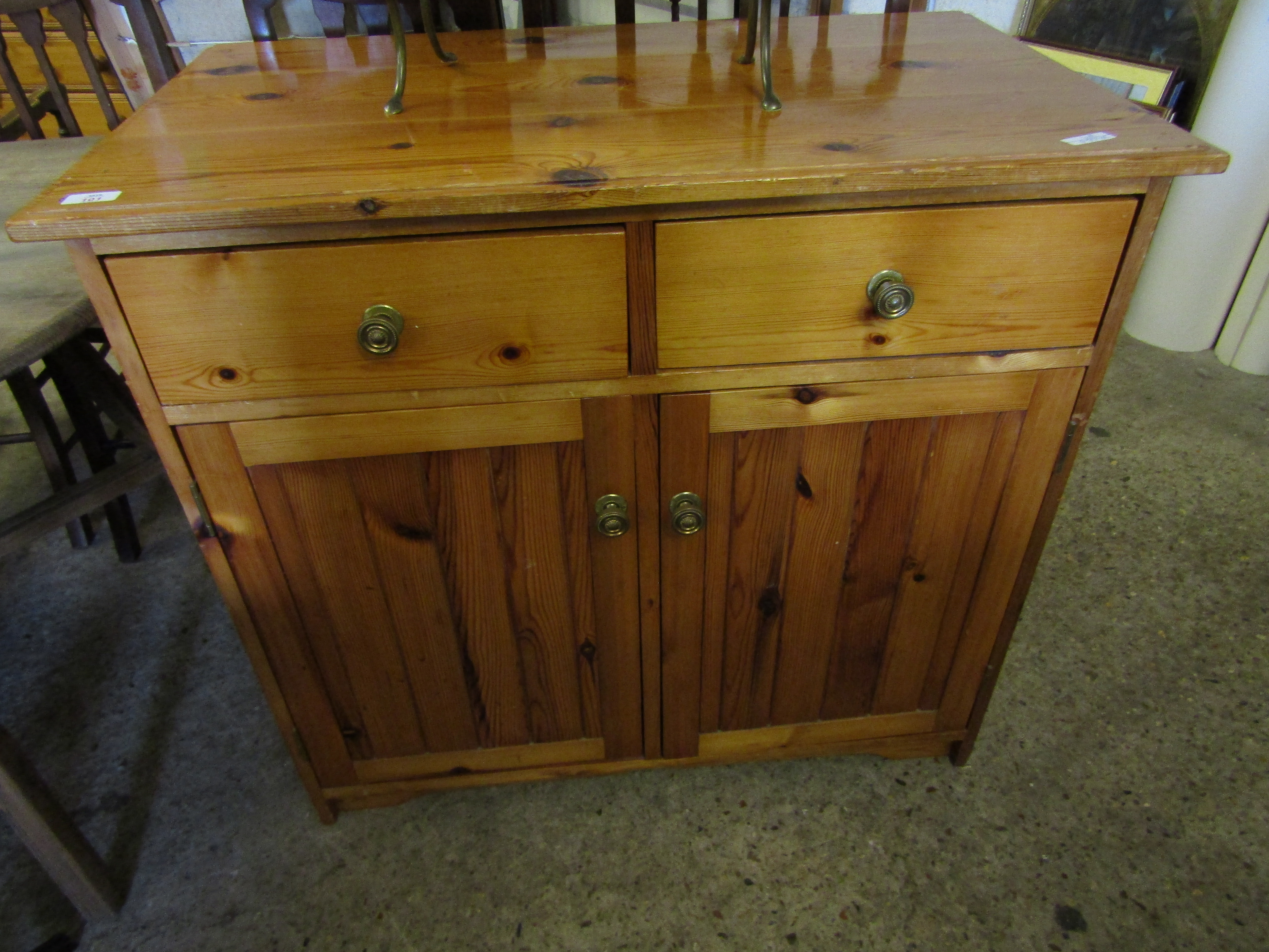 STAINED PINE CUPBOARD FITTED WITH TWO DRAWERS OVER TWO PANELLED CUPBOARD DOORS WITH BRASS KNOB