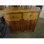 STAINED PINE CUPBOARD FITTED WITH TWO DRAWERS OVER TWO PANELLED CUPBOARD DOORS WITH BRASS KNOB