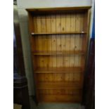 STAINED PINE FRAMED FOUR FIXED SHELF BOOKCASE WITH PANELLED BACK