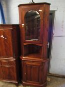 STAINED PINE FLOOR STANDING CORNER CUPBOARD WITH GLAZED DOOR, OPEN SHELF AND PANELLED CUPBOARD