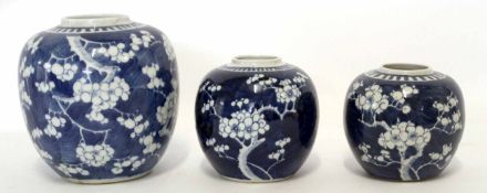 Group of three Chinese porcelain globular jars all decorated with prunus on a blue ground, the