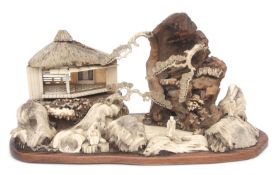 Intricate Japanese diorama depicting a mountainous landscape with pavilions and figures in wood,