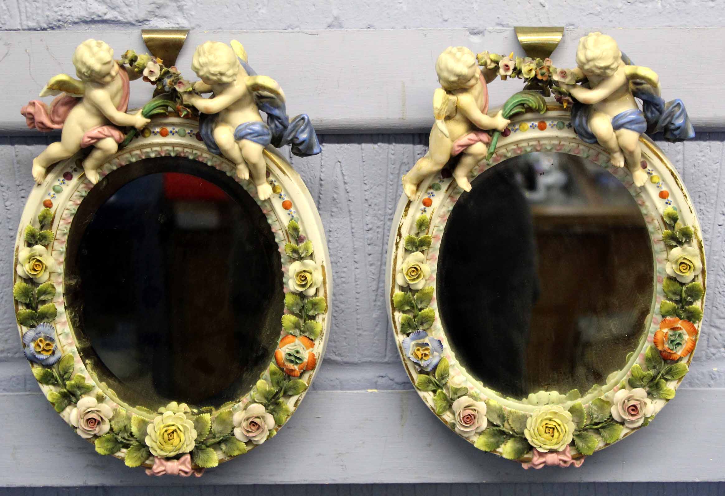 Late 19th century Dresden porcelain wall mirrors, oval shaped with applied floral decoration and