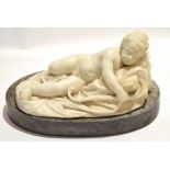 Carved marble figure of a reclined Cupid resting, minor losses, on grey marble base, 37cm x 19cm