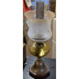 Late Victorian/early 20th century oil lamp with later shade over an amber glass font raised on