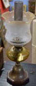 Late Victorian/early 20th century oil lamp with later shade over an amber glass font raised on