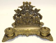 Victorian style cast brass ink stand of shaped rectangular form, having two circular lidded ink pots