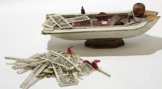 Bag of assorted ivory items including model of a boat, early 20th century, and a number of small