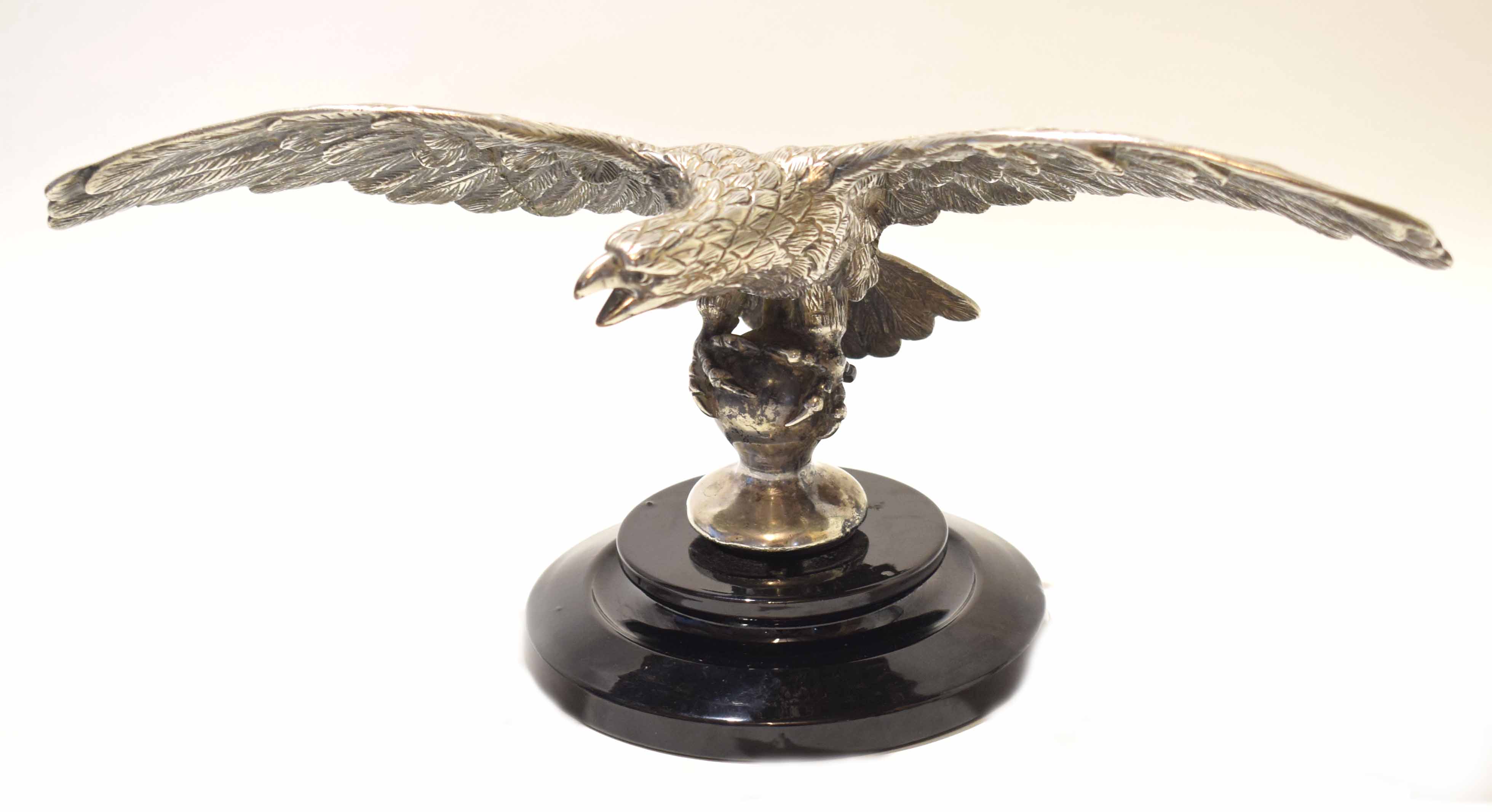 Early/mid-20th century silver plated model of an eagle with wings spread, seated on a ball, black