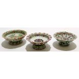 Three Chinese porcelain Qing Dynasty bowls on stem feet, all with polychrome designs, one famille