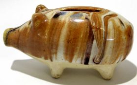 English pottery money box modelled as a pig, decorated with a Whealden type glaze on four stub feet,