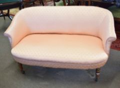 Small Victorian walnut boudoir settee on front turned legs and casters, upholstered in gold fleur de