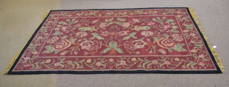 Good quality needlepoint type carpet with red ground and floral design with black border, 58cm