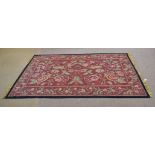 Good quality needlepoint type carpet with red ground and floral design with black border, 58cm