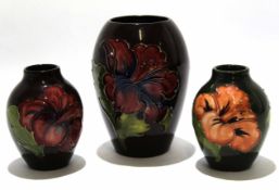 Group of three Moorcroft vases, all with tube lined floral design on brown ground, largest 13cm high