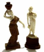 Two ivory type models of ladies, one carrying a water jug on her head, both on wooden mounts,