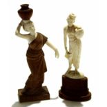 Two ivory type models of ladies, one carrying a water jug on her head, both on wooden mounts,