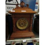 OAK MANTEL CLOCK WITH BRASS ARABIC CHAPTER RING AND CARVED DETAIL WITH STEPPED BASE